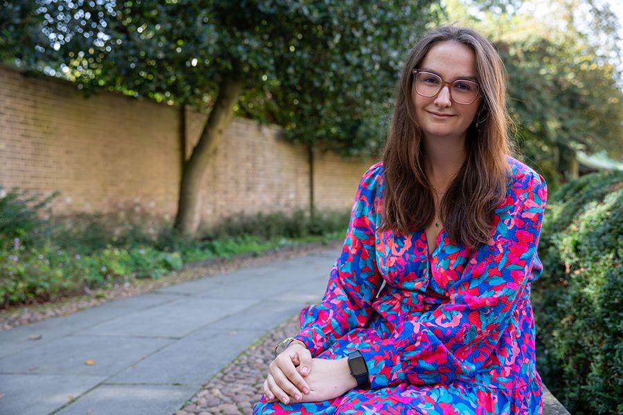 Kirstie Stage sitting on a wall in the gardens at Christ's College