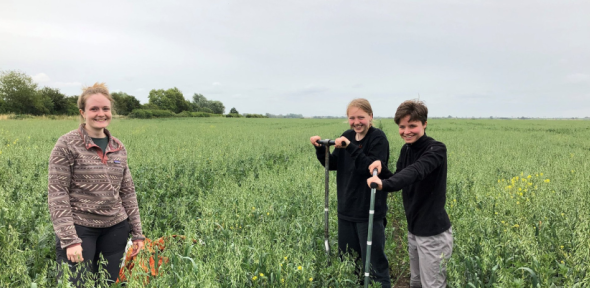 Students pose for a photo in a green field 
