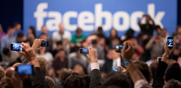 Members of the audience take pictures as President Barack Obama participates in a town hall meeting moderated by CEO Mark Zuckerberg at Facebook headquarters in Palo Alto, Calif. April 20, 2011