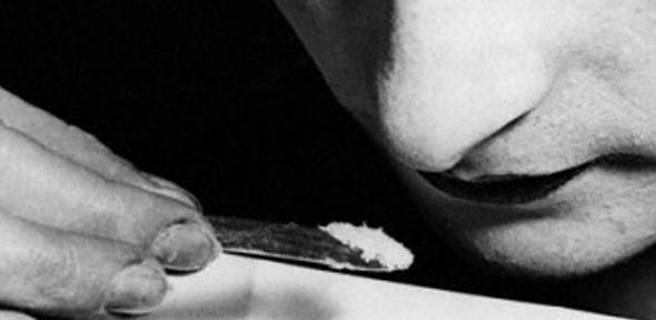 A close up of a young woman snorting cocaine during the 1920s