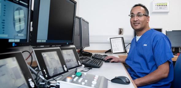 Dr Raj Jena in front of a computer