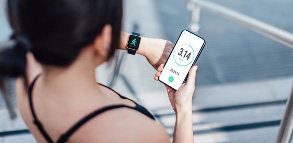 Woman checking her smart watch and mobile phone after run