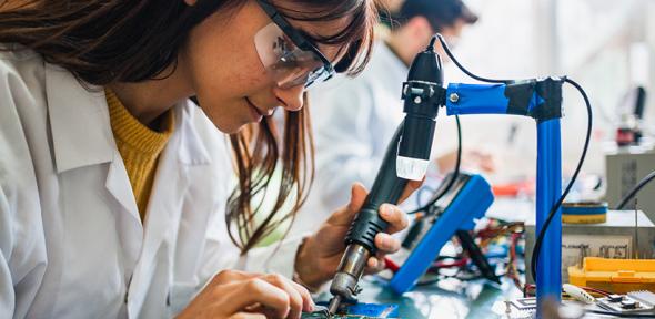 Two people working on circuit boards in an office