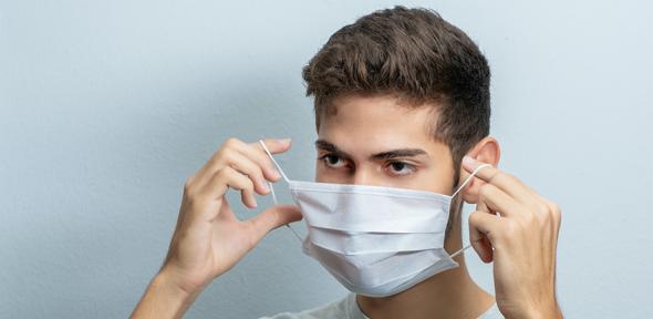 Man putting on a facemask