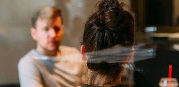 Two people speaking, sat at a table