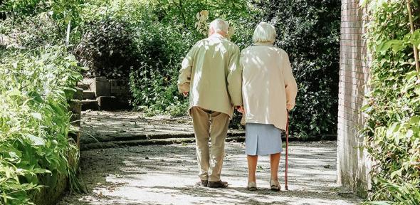 Elderly couple taking a walk through the park