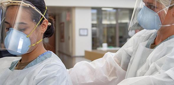 Medical personnel putting on PPE