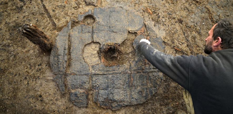 Excavation of Bronze Age Wheel at Must Farm one metre in diameter, with hub clearly visible. 