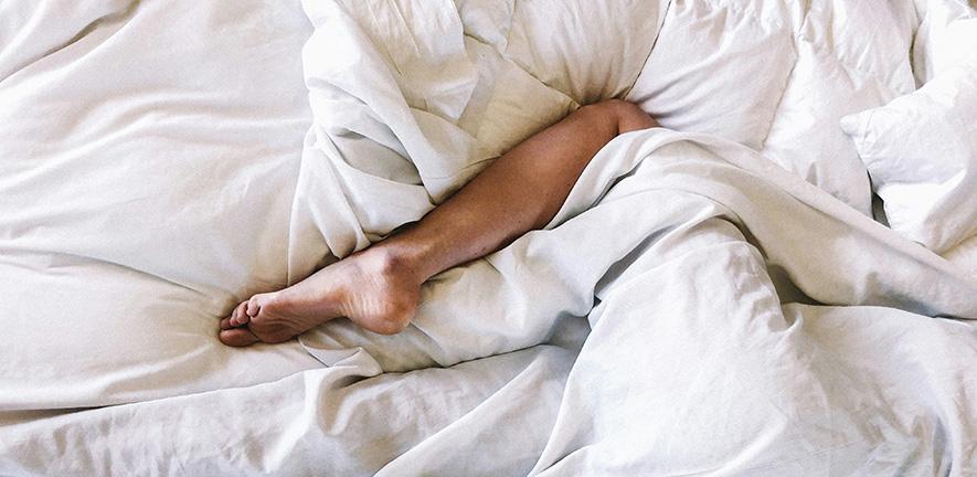 Leg sticking out from a white blanket