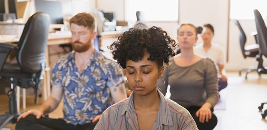 Serene creative business people meditating in office