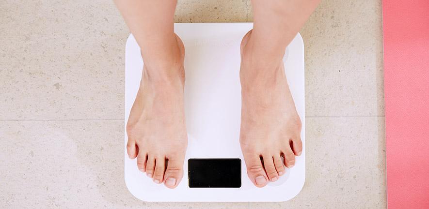 Person standing on white digital bathroom scale