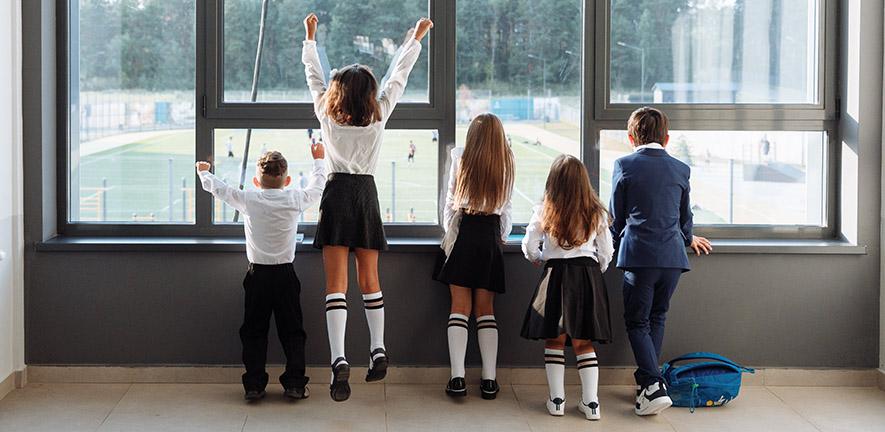 School children watching a sports game from indoors