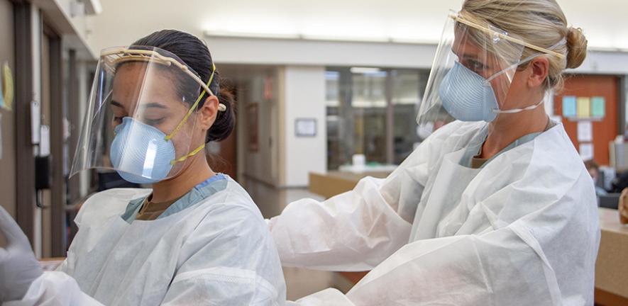 Medical personnel putting on PPE