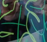 Two students creating art installation drawing on glass