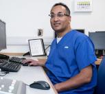 Dr Raj Jena in front of a computer