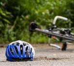 Cycling helmet lying on the floor by a crashed bicycle