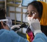 UK Emergency Medical Team paediatric nurse checks a girl for symptoms of Diphtheria in the Kutapalong refugee camp, Bangladesh
