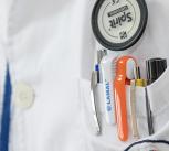 Doctor's white coat with stethoscope and pens