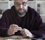 Man using blood sugar measurement device to monitor diabetes - stock photo