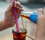 Child's hands pouring a drink into a glass