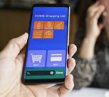 Hand holding a smartphone showing an online supermarket