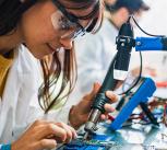 Two people working on circuit boards in an office