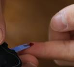 An Asian teenager with type 1 diabetes uses an at home glucometer to test his blood sugar levels