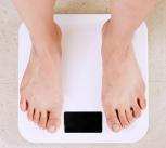 Person standing on white digital bathroom scale