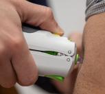 Vaccine being administered by needle-free injection into a volunteer's arm