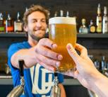 Barman handing a customer a pint of beer