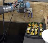 Robot arm reaching for a piece of broccoli
