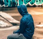 Teenager sitting near graffiti