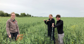 Students pose for a photo in a green field 
