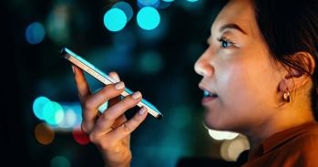 Young woman talking with AI voice virtual assistant on smartphone