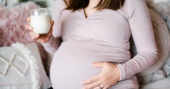Pregnant women drinking a glass of milk.