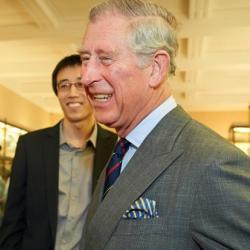 King Charles smiling with a group of Cambridge students