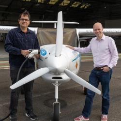 Dr Deepanshu Singh and Eliot Whittington stand next to electric plan