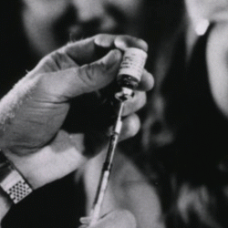 A Clinical Center physician prepares an injection for a young patient