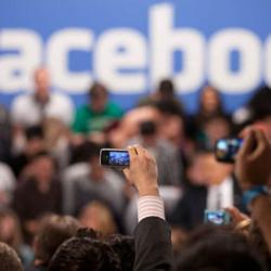 Members of the audience take pictures as President Barack Obama participates in a town hall meeting moderated by CEO Mark Zuckerberg at Facebook headquarters in Palo Alto, Calif. April 20, 2011