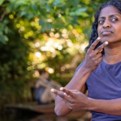 Actress Nadia Nadarajah recites a poem using British Sign Language 