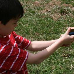 Boy playing with a toy gun made of wood