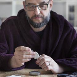 Man using blood sugar measurement device to monitor diabetes - stock photo