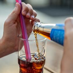 Child's hands pouring a drink into a glass