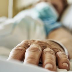 Senior woman wearing face mask lying on hospital bed