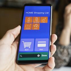 Hand holding a smartphone showing an online supermarket