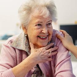 Smiling elderly woman speaking to a healthcare worker