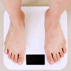 Person standing on white digital bathroom scale