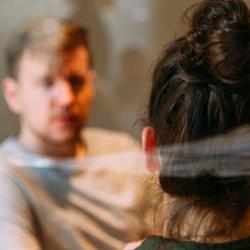 Two people speaking, sat at a table