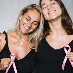 Two women holding pink ribbons