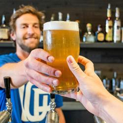 Barman handing a customer a pint of beer